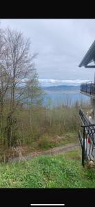 a bench on the side of a house with a view of the water at Choucas in Thollon