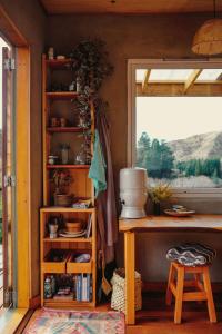 a kitchen with a counter and a table and a window at Lime Hut with wood burning sauna - Waipara Narrows in Glasnevin