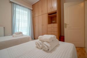 a bedroom with two beds with towels on them at Villa28 Harmony in Paleros