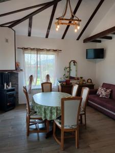 a dining room and living room with a table and chairs at Desculti prin iarba- la 6,6 km de centrul Piatra Neamt in Piatra Neamţ