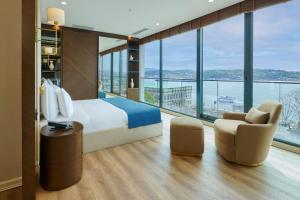 une chambre d'hôtel avec un lit et une grande fenêtre dans l'établissement Çırağan Hotel Bosphorus, à Istanbul