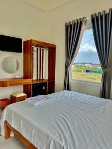 a bedroom with a bed and a large window at K Hotel Phú Quý in Cu Lao Thu