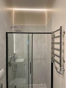 a bathroom with a glass shower with a sink at Lucky Apartmens in centre Lviv in Lviv