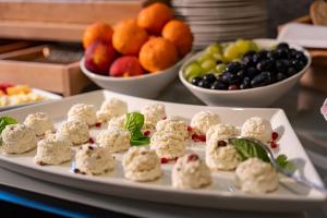a plate of food on a table with bowls of fruit at Hotel Grand Sal Kopalnia Soli "Wieliczka" in Wieliczka