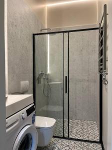a bathroom with a shower with a toilet and a sink at Lucky Apartmens in centre Lviv in Lviv +5 photos