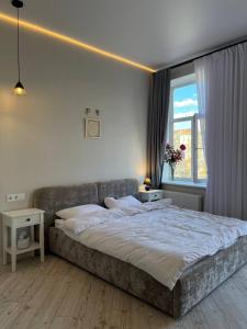 a bedroom with a large bed and a window at Lucky Apartmens in centre Lviv in Lviv