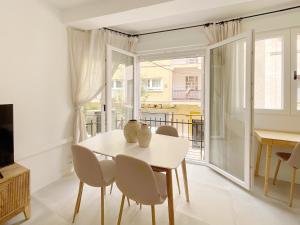 a dining room with a table and chairs and a window at KS Plaza Catedral by Kaleria Suites in Almería