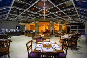 a restaurant with tables and chairs in a room at Chances Resort and Casino An Indy Resort in Panaji