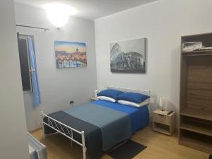a bedroom with a bed with blue pillows at Alloggio Fiorella in Rome