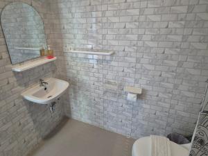 a white bathroom with a sink and a mirror at Dorothys in Pattaya South +37 photos