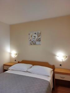 ein Schlafzimmer mit einem Bett mit zwei Tischen und einem Gemälde in der Unterkunft Casa Panorama Sunrise in Rabac + 30 Fotos