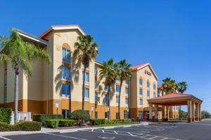a large building with palm trees in a parking lot at Comfort Inn & Suites Orlando North in Sanford