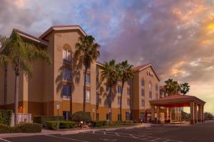 a building with palm trees in front of a parking lot at Comfort Inn & Suites Orlando North in Sanford