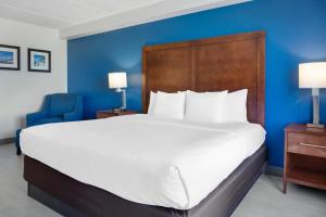 a large bed in a hotel room with a blue wall at Comfort Inn & Suites Orlando North in Sanford