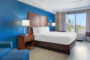 a bedroom with a bed and a blue wall at Comfort Inn & Suites Orlando North in Sanford