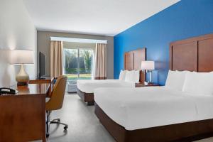 a hotel room with two beds and a desk at Comfort Inn & Suites Orlando North in Sanford
