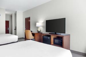 a hotel room with a bed and a flat screen tv at Comfort Inn & Suites Orlando North in Sanford