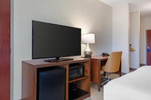 a room with a flat screen tv on a desk at Comfort Inn & Suites Orlando North in Sanford