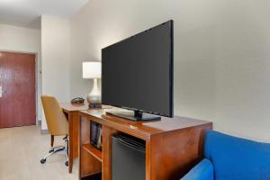 a flat screen tv sitting on top of a wooden desk at Comfort Inn & Suites Orlando North in Sanford