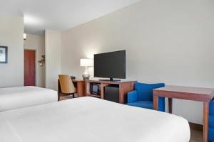 a hotel room with a bed and a flat screen tv at Comfort Inn & Suites Orlando North in Sanford