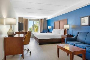 a hotel room with a bed and a couch at Comfort Inn & Suites Orlando North in Sanford