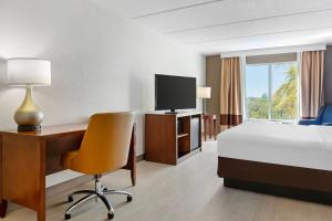 a hotel room with a bed and a desk and a television at Comfort Inn & Suites Orlando North in Sanford