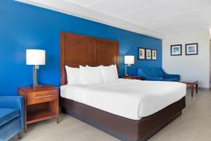 a bedroom with a large bed and a blue wall at Comfort Inn & Suites Orlando North in Sanford