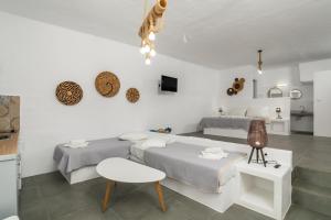 a bedroom with two beds and a table at Aqua Bay Agia Kyriaki in Agia Kiriaki Beach