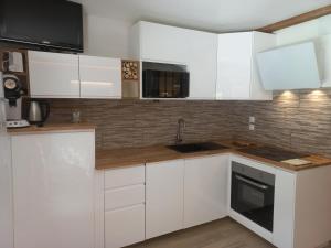 een witte keuken met witte kasten en een spoelbak bij Sur le TMB Les Contamines in Les Contamines-Montjoie +13 foto's