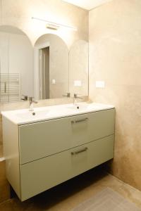 a bathroom with a white sink and a mirror at Maison Castor, balnéo et billard chez Ivona Vacances in Mimizan