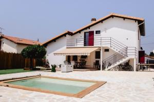 a villa with a swimming pool in front of a house at Maison Castor, balnéo et billard chez Ivona Vacances in Mimizan