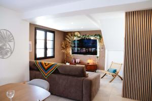 a living room with a couch and a table at Maison Castor, balnéo et billard chez Ivona Vacances in Mimizan
