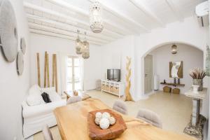a living room with a table and a couch at Marvi House Mykonos Holiday Home in Ornos