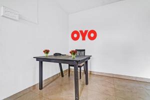 钦奈HOTEL O J2 SERVICE APARTMENT的墙上的桌子上放着鲜花