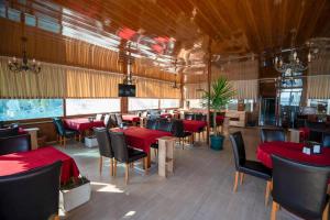 a restaurant with red tables and chairs in a room at Kutlugun Sahil Otel in Akçay