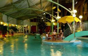 a swimming pool with people sitting at a table in the water at Holiday Spa Luxury Suite w Sauna FREE Parking in Tampere