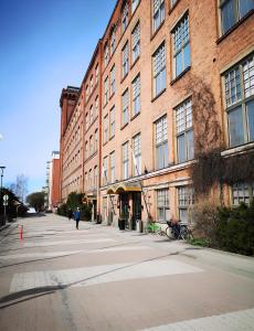an empty street in front of a large brick building at Holiday Spa Luxury Suite w Sauna FREE Parking in Tampere