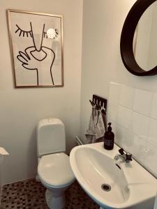 a bathroom with a white toilet and a sink at Casa Korallen - Central Apartment in Varberg +7 photos