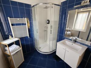a blue tiled bathroom with a shower and a sink at Alloggio Turistico Katarina House in Isola Sacra +19 photos
