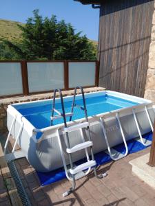 a swimming pool with a chair and a tub at Casa Rural A Ritmo De Burro in Robledondo