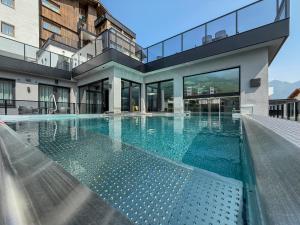 a house with a swimming pool in front of a building at A CASA Infinity in Serfaus