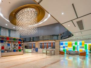 a lobby with a chandelier in a building at Calvin International Hotel Guangzhou Sanyuanli Metro Station Branch - Free Shuttle Bus to Canton Fair Complex During Canton Fair Period & Free Deliver Service to Guangzhou Baiyun International Airport in Guangzhou +67 photos