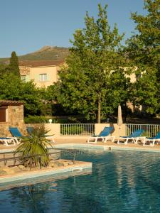 una piscina con sedie a sdraio e una piscina di Résidence Spelonca a Corbara
