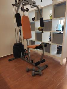 a gym with an orange chair in a room at Cosy Garden Bungalow in Messini