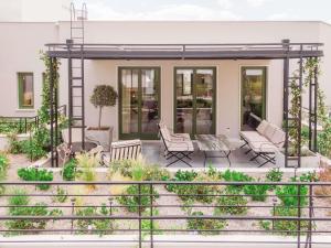 アテネにあるAthens Capital Suites-MGallery Collectionの家(椅子と植物のあるパティオ付)