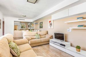 Villa Betty في كالا إن بلانيس: غرفة معيشة مع أريكة وتلفزيون