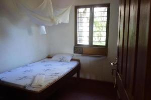 a small bedroom with a bed and a window at Juani Pangani in Pangani +9 photos