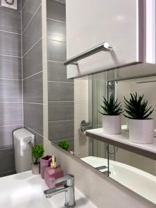 a bathroom with a sink and a mirror and plants at Apartment Laura in Senj +72 photos