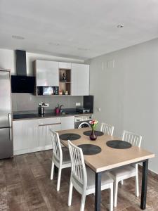 kuchnia ze stołem, krzesłami i lodówką w obiekcie Apartamento con Piscina ADULTS ONLY w mieście Chiclana de la Frontera
