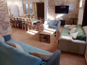 a living room with couches and a stone wall at Casa Rural A Ritmo De Burro in Robledondo